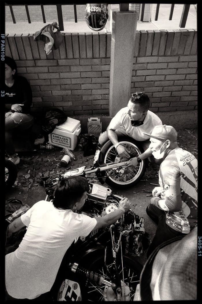 A group of men repairing a motorcycle on a street in Cúcuta, Colombia.