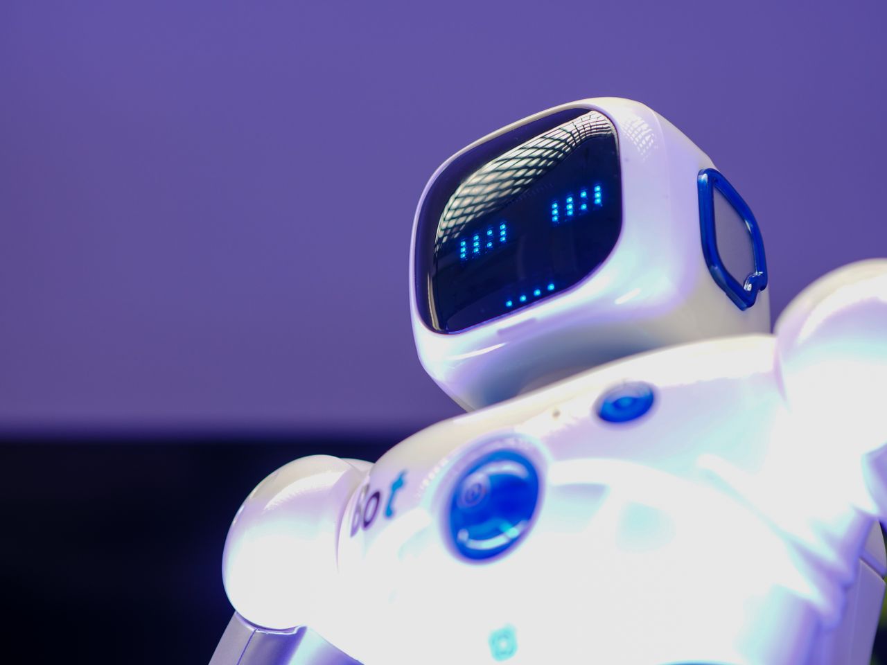 about-img A modern humanoid robot with digital face and luminescent screen, symbolizing innovation in technology.